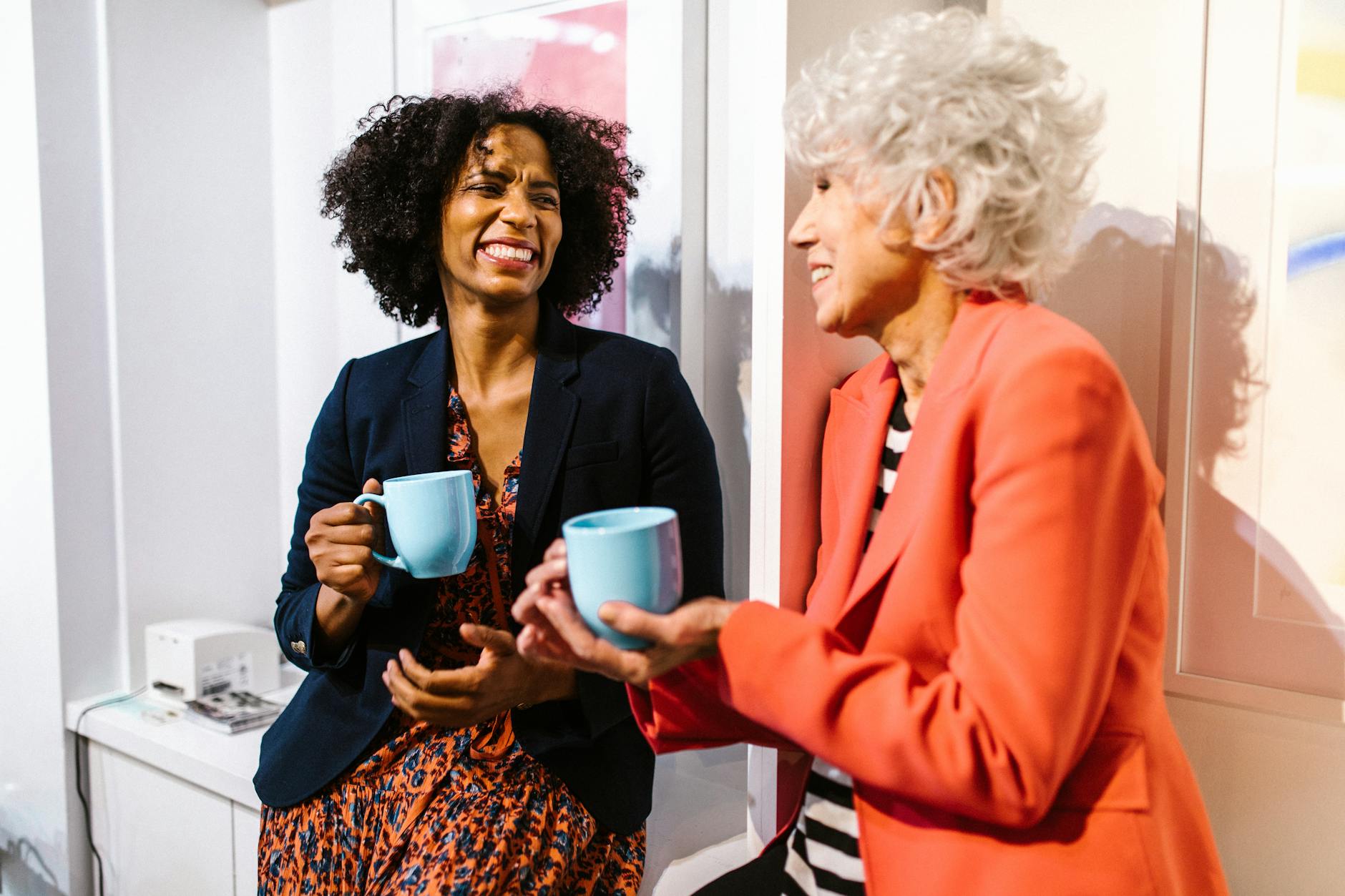 fashion-designer-34 woman in orange blazer holding blue ceramic mug